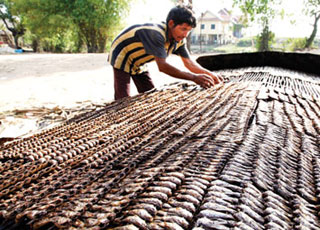 The skewered fish are laid on bamboo frames to be smoked for five or six hours